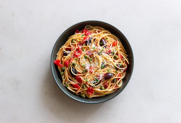 Pasta de espaguetis Alla Puttanesca con alcaparras Kalamata aceitunas queso tomates y anchoas comida italiana