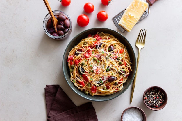 Pasta de espaguetis Alla Puttanesca con alcaparras Kalamata aceitunas queso tomates y anchoas comida italiana