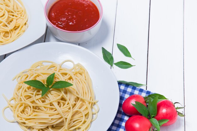 Pasta de espaguetis con salsa de tomate en el fondo de madera