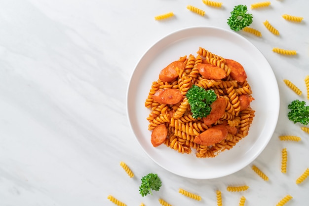 pasta en espiral o spirali con salsa de tomate y salchicha - estilo de comida italiana