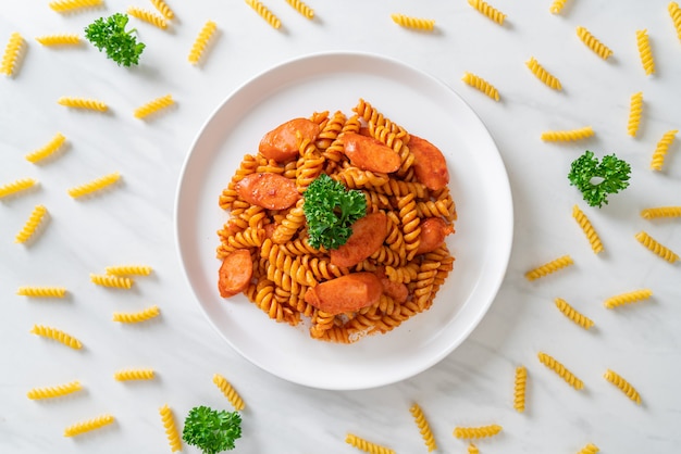 Pasta en espiral o spirali con salsa de tomate y salchicha, estilo italiano