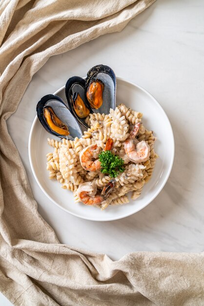 Pasta espiral con salsa de crema de champiñones y mariscos - estilo de comida italiana