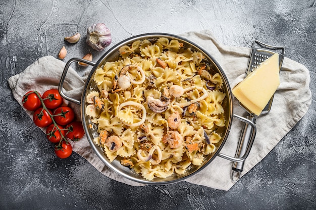 Pasta farfale mit Meeresfrüchten, Tintenfisch, Garnelen, Tintenfisch, Jakobsmuscheln und Muscheln. Ansicht von oben