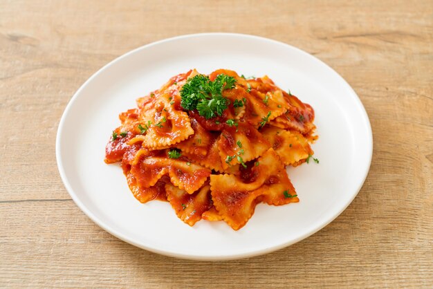 Foto pasta farfalle em molho de tomate com salsa de salsa