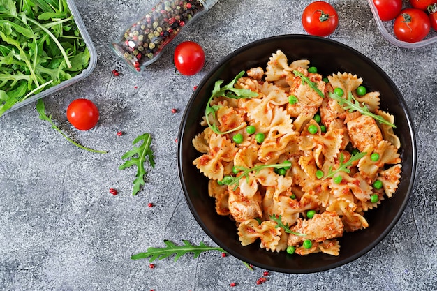 Pasta Farfalle con filete de pollo, salsa de tomate y guisantes. Cocina italiana. Menú. Vista superior. Cena. Endecha plana.