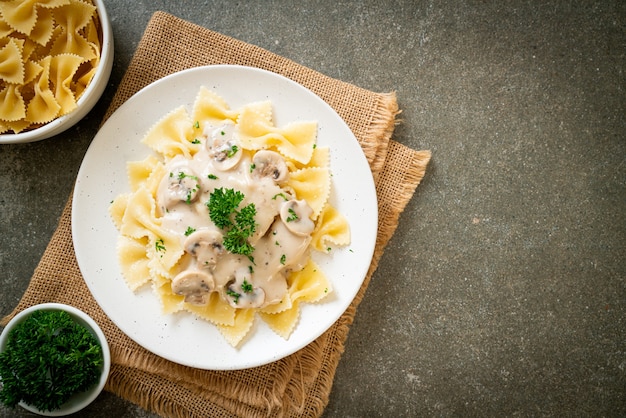 pasta farfalle con salsa de crema blanca de champiñones - estilo de comida italiana