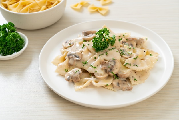 pasta farfalle con salsa de crema blanca de champiñones - estilo de comida italiana