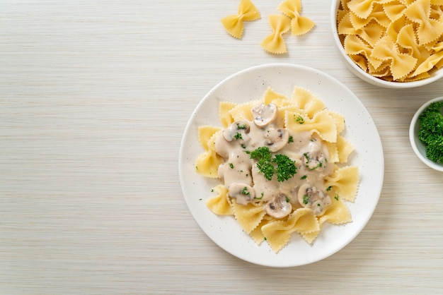 pasta farfalle con salsa de crema blanca de champiñones - estilo de comida italiana