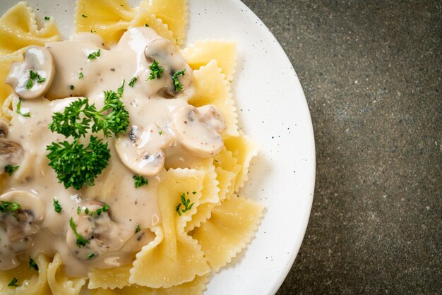 pasta farfalle con salsa de crema blanca de champiñones - estilo de comida italiana