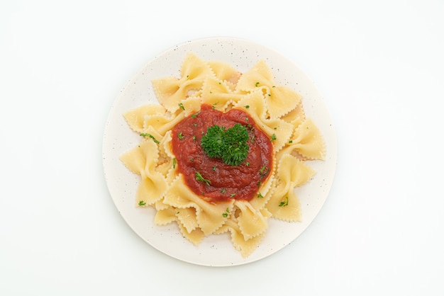 Pasta farfalle en salsa de tomate con perejil aislado