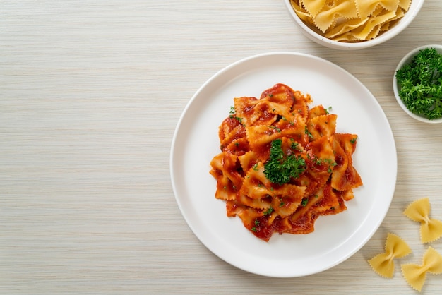 pasta farfalle en salsa de tomate con perejil - estilo de comida italiana