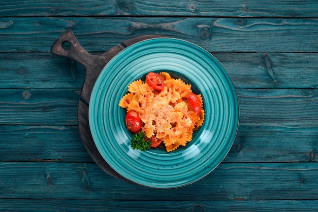 Foto pasta farfalle con tomates y queso parmesano cocina italiana sobre un fondo de madera vista superior espacio de copia