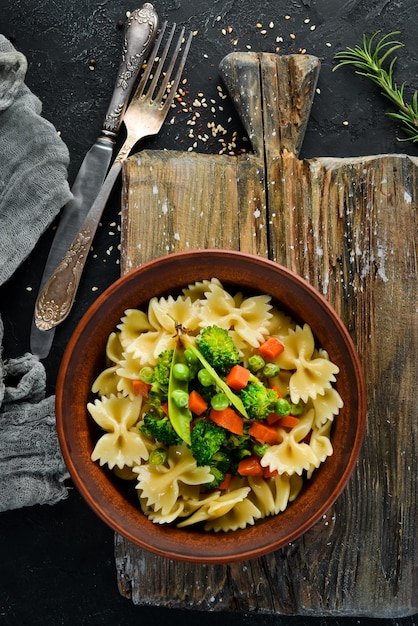 Pasta Farfalle con verduras en el plato Vista superior Sobre un fondo negro Espacio de copia libre