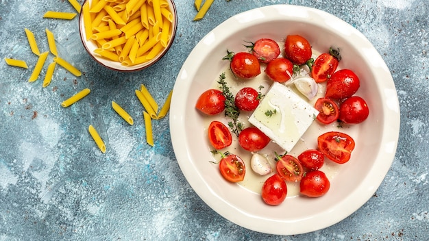 Pasta feta al horno. tomates cherry al horno y queso feta con aceite de oliva