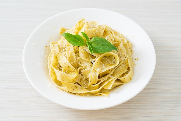 pasta fettuccine al pesto con queso parmesano encima - estilo de comida italiana