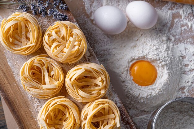 Pasta fettuccine casera doblada en forma de nido Cocina casera con ingredientes para la pasta fettuccine italiana tradicional casera