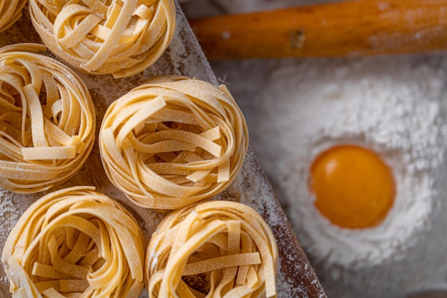 Pasta fettuccine casera doblada en forma de nido Cocina casera con ingredientes para la pasta fettuccine italiana tradicional casera