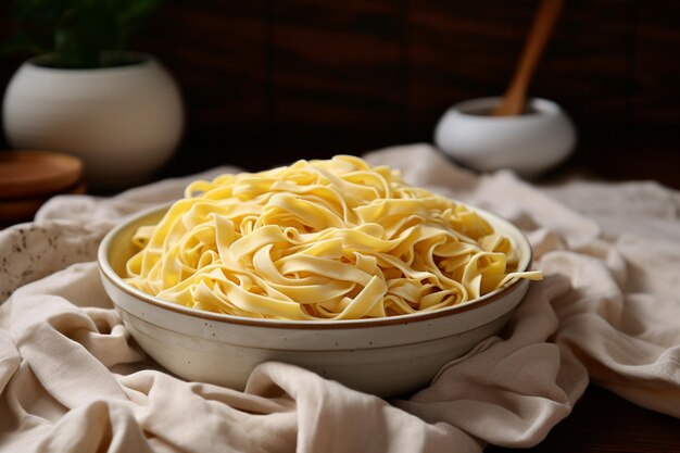 Pasta de fettuccine con espagueti en un cuenco sobre un fondo de madera y toalla de cocina