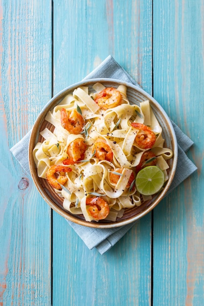 Pasta fettuccine en salsa cremosa con gambas, lima y salvia comida italiana