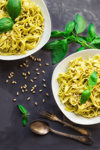 Pasta fettuccine con salsa pesto, albahaca y piñones sobre hormigón. Cocina italiana. Vista superior