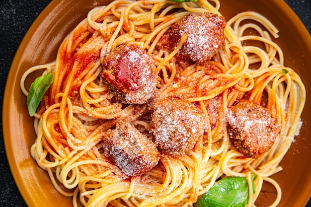 Pasta, Fleischkugeln, Spaghetti, Tomatensauce, geriebener Parmesan, Käse, Mahlzeit, Nahrung, Snack auf dem Tisch