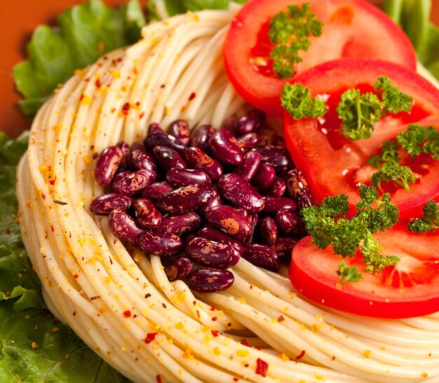 Pasta con frijoles al horno y tomates frescos.