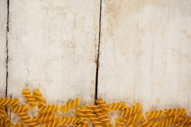 Pasta fusilli aislado sobre mesa de madera