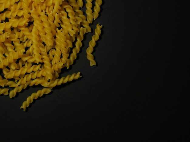 Foto pasta fusilli y espaguetis sobre un fondo negro