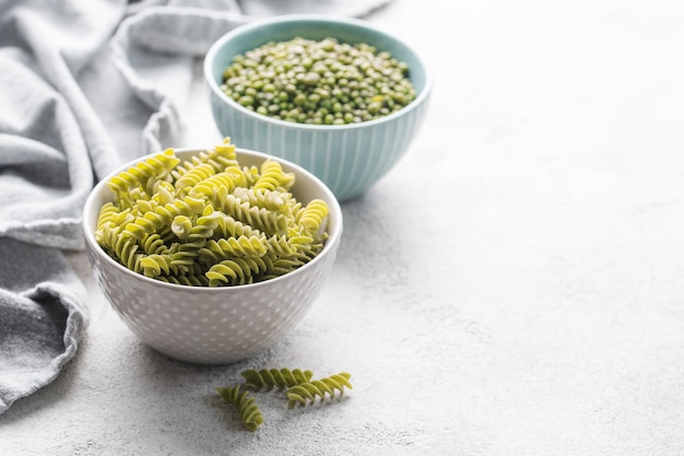 Pasta fusilli de frijol mungo Cuenco con pasta cruda y frijol mungo verde Pasta sin gluten