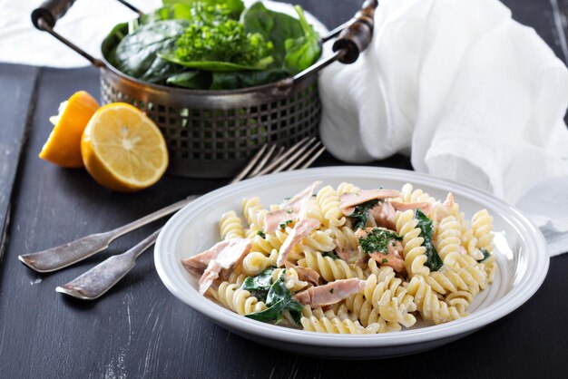 Foto pasta fusilli con salmón al horno y espinacas