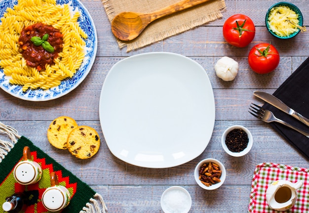 Foto pasta fusilli con salsa de tomate y más ingredientes en una mesa de madera