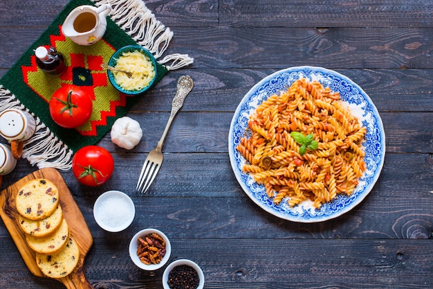 Pasta fusilli con salsa de tomate, tomate, cebolla, ajo, pimentón seco, aceitunas, pimiento y aceite de oliva.