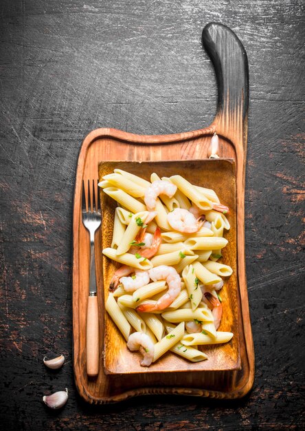 Pasta con gambas en un plato con tenedor