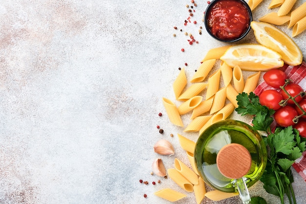 Pasta-Hintergrund. Pasta Rigati, Tomatenketchupsauce, Olivenöl, Gewürze Petersilie und frische Tomaten