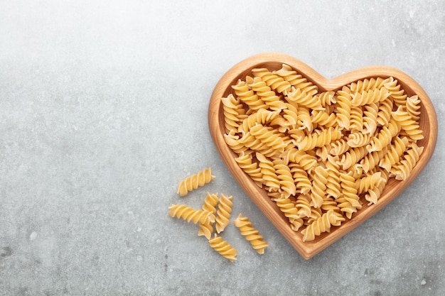 Pasta in einer herzförmigen Holzschale