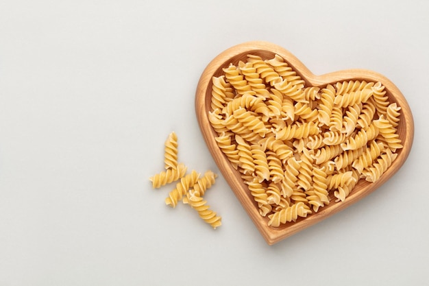 Foto pasta in einer herzförmigen holzschale