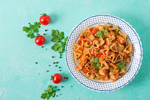 Pasta in Form von Herzen mit Huhn und Tomaten in Tomatensoße. Draufsicht