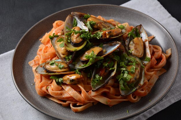 Pasta in Tomatensauce mit gebratenen Muscheln und Kräutern