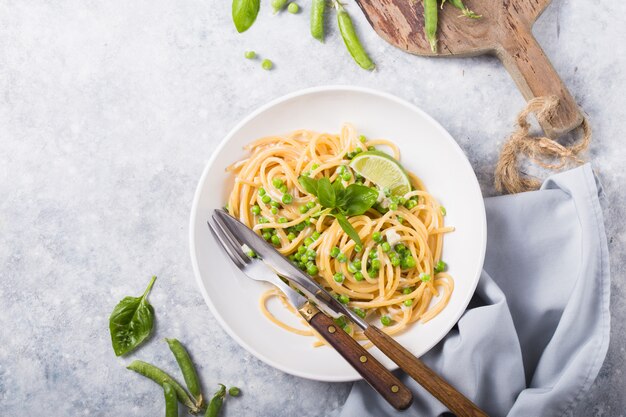 Pasta italiana Cacio Pepe - espaguetis con queso y guisantes verdes