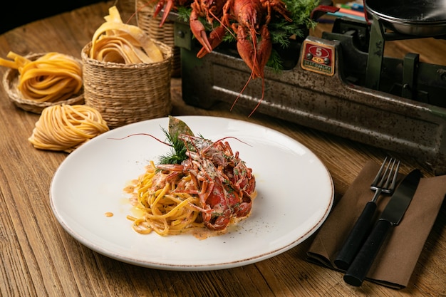 Pasta italiana con cangrejos de río hervidos y salsa sobre una mesa de madera de la granja