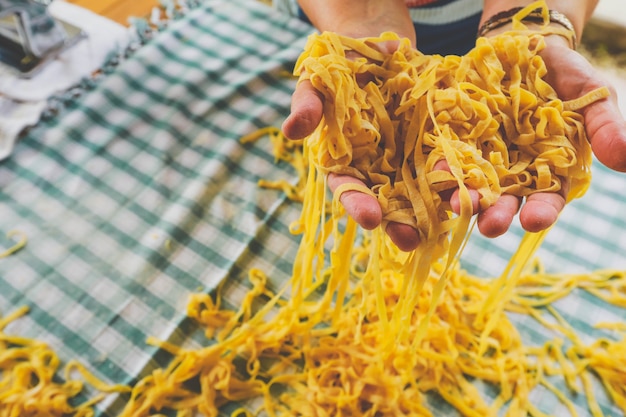 Pasta italiana casera, manos de una persona que hace pasta fresca