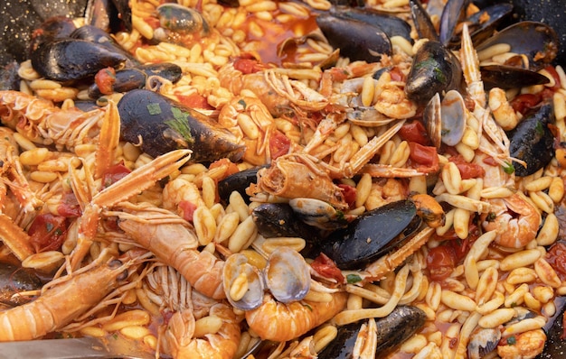 Pasta italiana Cavatelli allo scoglio con mariscos y tomates de cerca en una sartén