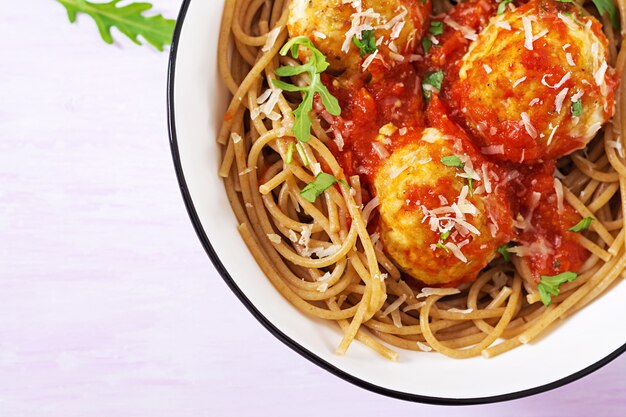 Pasta italiana. Espaguetis con albóndigas y queso parmesano en un tazón en la mesa de madera rústica ligera. Cena. Vista superior. Concepto de comida lenta