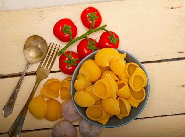 Pasta italiana lumaconi de caracol con tomates