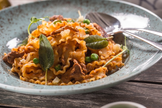 Pasta italiana mafalde setas guisantes y salsa de tomate.