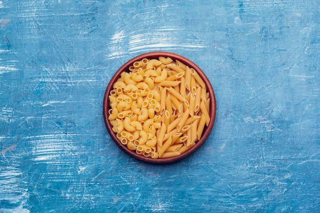 Pasta italiana en placa sobre una mesa de madera azul