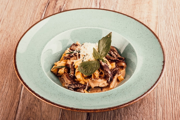 Pasta italiana con salsa de carne en un plato sobre un fondo de madera vista superior