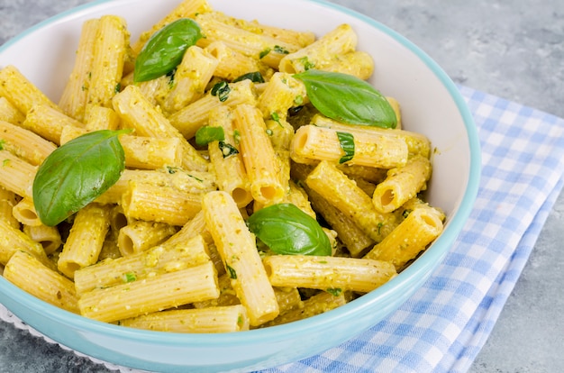 Pasta italiana con salsa de pesto y hojas de albahaca.