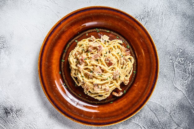 Pasta italiana Spaghetti Carbonara con tocino, queso parmesano duro y salsa de crema. vista superior.