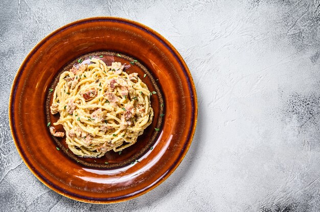 Pasta italiana Spaghetti Carbonara con tocino, queso parmesano duro y salsa de crema.